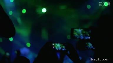 人们拿着智能手机在舞台上拍摄表演的慢动作镜头